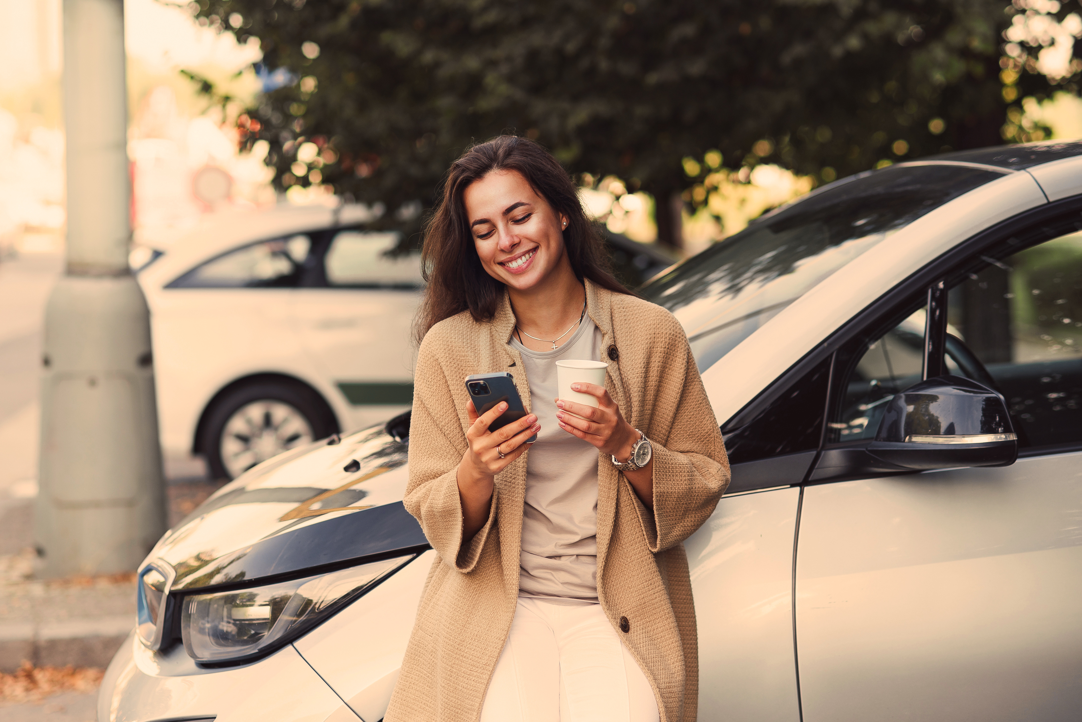 AdobeStock_457934968_Moteris automobilyje su išmaniuoju telefonu